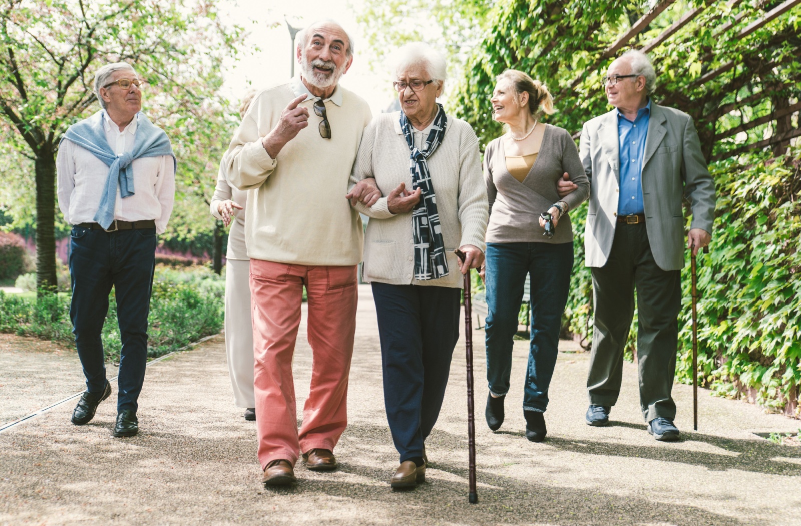 A group of older adults socializing and walking outdoors.