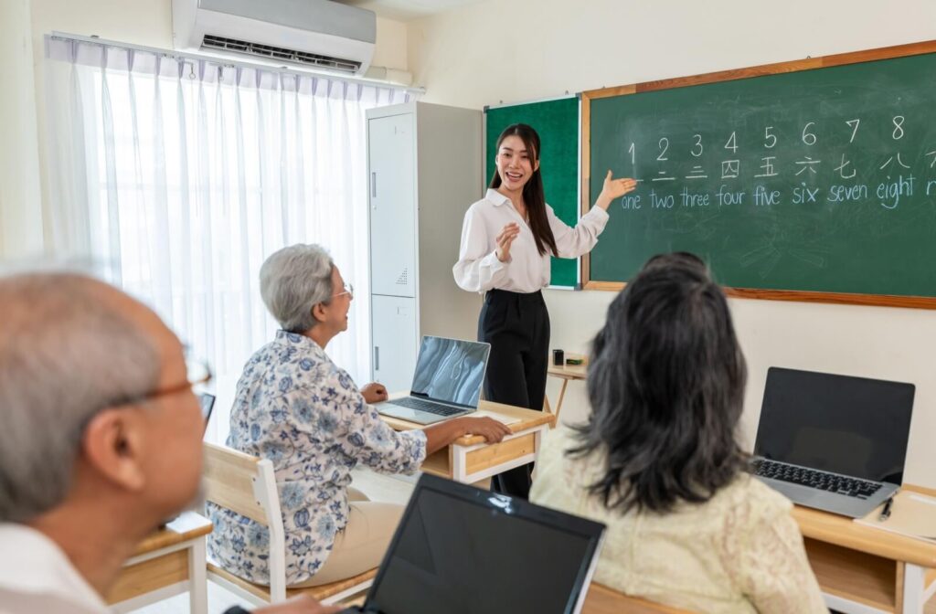 A group of seniors pays attention to their instructor during an adult education class on learning a foreign language