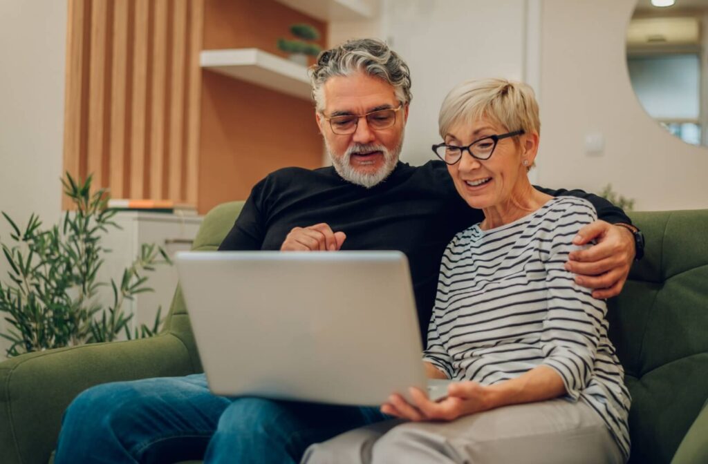 A senior couple use a computer to research respite care communities in their community, looking to test out senior living
